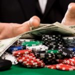 poker player with chips and money at casino table